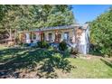 Quaint home with a covered front porch, showcasing a well-maintained lawn and mature trees at 6312 Bill Ledford Rd, Vale, NC 28168