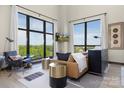 Inviting living room with large windows and a view, furnished with a leather couch and modern side tables at 715 N Church St # 816, Charlotte, NC 28202