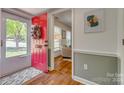 Inviting foyer featuring a red door, wood floors, and a glimpse into the living area at 7300 Chatterbird Ct, Charlotte, NC 28226