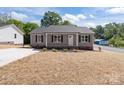 Charming single-story home featuring a well-manicured lawn and inviting front porch, perfect for relaxing evenings at 104 Cleveland Ave, Albemarle, NC 28001