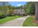 Charming two-story home with lush landscaping, a long driveway, and a welcoming facade at 116 Anderson Farm Ct, Mooresville, NC 28117