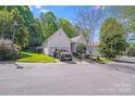 Well-maintained home featuring a manicured lawn, attached garage, and lush greenery at 13817 Kings Carriage Ln, Charlotte, NC 28278