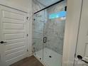 Modern bathroom featuring a frameless glass shower with stylish marble-look tile and black fixtures at 142 Prestwick Way # 18, Mooresville, NC 28115