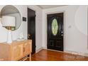 Light and airy entryway features hardwood floors, decorative mirror and a stylish front door at 1501 Briarfield Dr, Charlotte, NC 28205