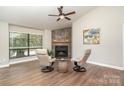 Bright living room features a stone fireplace, high ceilings, and modern decor at 1600 Sharon W Rd # 8, Charlotte, NC 28210