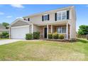 Two-story home with stone accents, a well-maintained lawn, and a welcoming front porch at 1849 Meadow Crossing Dr # 118, Huntersville, NC 28078