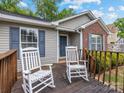 Cozy covered front porch with rocking chairs, wood railing, blue shutters, and neutral siding at 3022 Willamette Valley Dr, Charlotte, NC 28215