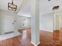 Open living room featuring hardwood floors, abundant natural light, and modern lighting fixtures at 3022 Willamette Valley Dr, Charlotte, NC 28215
