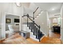 Inviting foyer showcasing a staircase with dark railings, hardwood floors, and access to the living spaces creating an open feel at 3908 Brittany Ct, Indian Trail, NC 28079