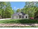 Beautifully landscaped modern home with white painted brick, a black roof, and black trim at 5538 Camelot Dr, Charlotte, NC 28270