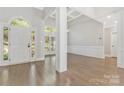 Open foyer with hardwood flooring, white trim, large windows and arched entryway at 5538 Camelot Dr, Charlotte, NC 28270