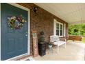Cozy front porch featuring a bench, brick exterior, and a decorative wreath on the front door at 5840 Shirley Rd, Fort Lawn, SC 29714