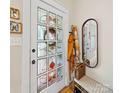 Entryway showcases a stained glass door, wicker bench, coat rack and decorative mirror for a charming welcome at 705 N Fulton St, Salisbury, NC 28144
