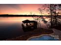 Picturesque lakeside retreat featuring a private dock and tranquil waters, perfect for boating and enjoying scenic sunsets at 8058 Edgewater Dr, Norwood, NC 28128