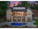 Striking two-story home with a spacious balcony, stone pillars, and a sparkling pool for ultimate relaxation and entertainment at 8058 Edgewater Dr, Norwood, NC 28128