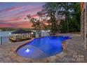 Beautiful pool with an adjacent lake, complemented by a charming dock for serene waterfront enjoyment and recreation at 8058 Edgewater Dr, Norwood, NC 28128