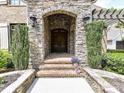 Stone archway with a brick walkway and double front doors providing an inviting entry at 825 Hudson Pl, Davidson, NC 28036