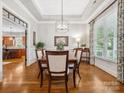 Formal dining room featuring a tray ceiling, hardwood floors, and ample natural light from a large window at 894 Stratford Run Dr, Fort Mill, SC 29708