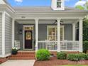 Inviting front porch with white columns, brick steps, and a decorative front door with glass inserts at 894 Stratford Run Dr, Fort Mill, SC 29708