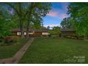 Inviting home with a stone pathway leading to the front door, surrounded by a well-manicured lawn and mature trees at 916 E Park Dr, Lincolnton, NC 28092