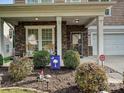 Inviting front porch with stone accents, rocking chairs, and manicured landscaping at 1033 Lilly Pond Dr, Fort Mill, SC 29715