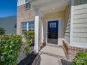 Inviting front entrance featuring a stylish black door, brick accents, and decorative shrubbery at 1210 Longwall Ln, Matthews, NC 28104