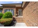 Close-up of a brick home's front entry with a charming wreath, steps, and manicured landscaping, offering curb appeal at 123 Shoreview Dr, Mooresville, NC 28117