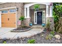 Charming front entry featuring stone accents, lovely landscaping, and a welcoming front door at 13936 Mallard Lake Rd, Charlotte, NC 28262