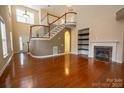 Open-concept living area features a fireplace, staircase, and hardwood floors at 13936 Mallard Lake Rd, Charlotte, NC 28262