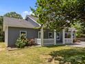 Inviting home boasting a cozy front porch with white columns, beautiful landscaping, and a well-manicured lawn at 14532 E Rocky River Rd, Davidson, NC 28036