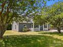 Quaint home featuring gray siding, a white picket fence, and lush landscaping, creating a serene setting at 14532 E Rocky River Rd, Davidson, NC 28036
