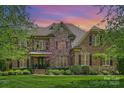 Charming brick and stone home featuring manicured lawn and lush landscaping in a sought-after neighborhood at 2001 Arundale Ln, Matthews, NC 28104