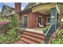 Charming front porch with brick stairs, iron railings, and comfortable seating, offering a relaxing outdoor space with neighborhood views at 2229 Kenmore Ave, Charlotte, NC 28204