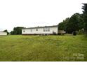Large backyard featuring a grassy lawn and mature trees at 234 Olin Loop, Olin, NC 28660
