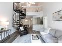 Open-concept living room with a spiral staircase, modern furnishings, and a view of the dining area at 2504 Stradbrook Dr # B, Charlotte, NC 28210