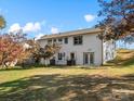 Large, grassy backyard with a white two-story house featuring a walkout basement at 2701 N Sharon Amity Rd, Charlotte, NC 28205