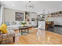 Open-concept living room and kitchen with hardwood floors, modern lighting, and eclectic decor at 2701 N Sharon Amity Rd, Charlotte, NC 28205