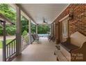Inviting covered porch with seating area, brick accents, and a view of the refreshing pool at 32060A Flint Ridge Rd, Albemarle, NC 28001