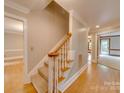 Inviting staircase with carpeted steps, hardwood floors, and a wooden banister at 5412 Crosshill Ct, Charlotte, NC 28277