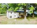 Lush backyard with mature trees and a wooden balcony that is attached to the home at 5520 Chestnut Dr, Hickory, NC 28602