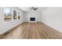 Bright living room with a white brick fireplace, ceiling fan, and luxury vinyl flooring at 5520 Chestnut Dr, Hickory, NC 28602