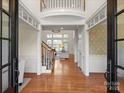 Grand foyer with hardwood floors, soaring ceilings, and a view of the staircase and living room at 5809 Woodleigh Oaks Dr, Charlotte, NC 28226