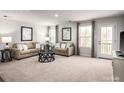 Spacious living room with neutral decor, plush carpeting, ample natural light, and access to outdoor balcony at 69 Millstream Dr, China Grove, NC 28023