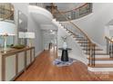 Grand foyer boasts a curved staircase, hardwood floors, and elegant decor at 7005 Camrose Crossing Ln, Matthews, NC 28104