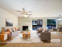 Bright living room features a fireplace, a ceiling fan, and natural light with a view of the outdoors at 7116 Winery Ln, Charlotte, NC 28227