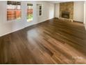Open-concept living room with sleek hardwood floors and a stone fireplace at 8026 Regent Park Ln, Charlotte, NC 28210