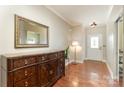 The foyer includes a beautiful wooden cabinet, mirror, hardwood floors, and a modern doorway at 9904 Rocky Ford Club Rd, Charlotte, NC 28269