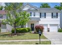 Traditional two-story home with a well manicured lawn, an attached two-car garage, and a small front porch at 9904 Rocky Ford Club Rd, Charlotte, NC 28269