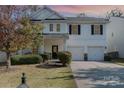 Two-story house with a front porch, two-car garage, landscaped yard, and traditional design at 9904 Rocky Ford Club Rd, Charlotte, NC 28269