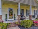 Inviting front porch featuring a comfortable sitting area, well manicured plants, and a beautifully decorated front door at 1009 Preston Dr, Lowell, NC 28098